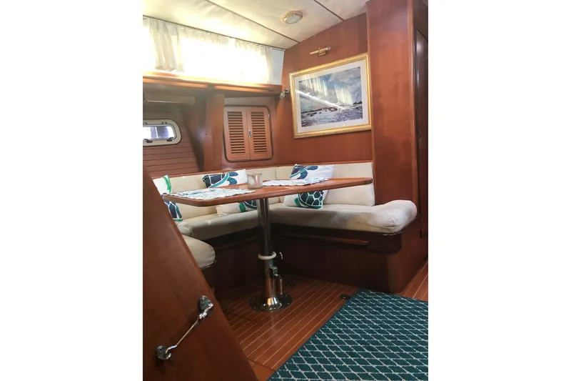 Slide: The Image of Cozy interior of 1999 Passport 456 yacht with wooden furnishings and cushioned seating. - 23