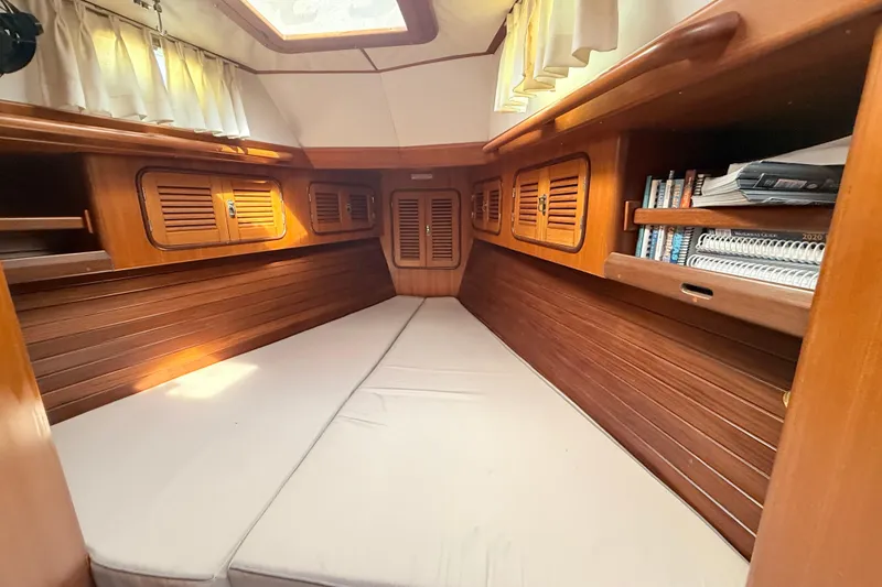 Slide: The Image of Cozy wooden cabin interior of a 1999 Passport 456 yacht with books and natural light. - 28