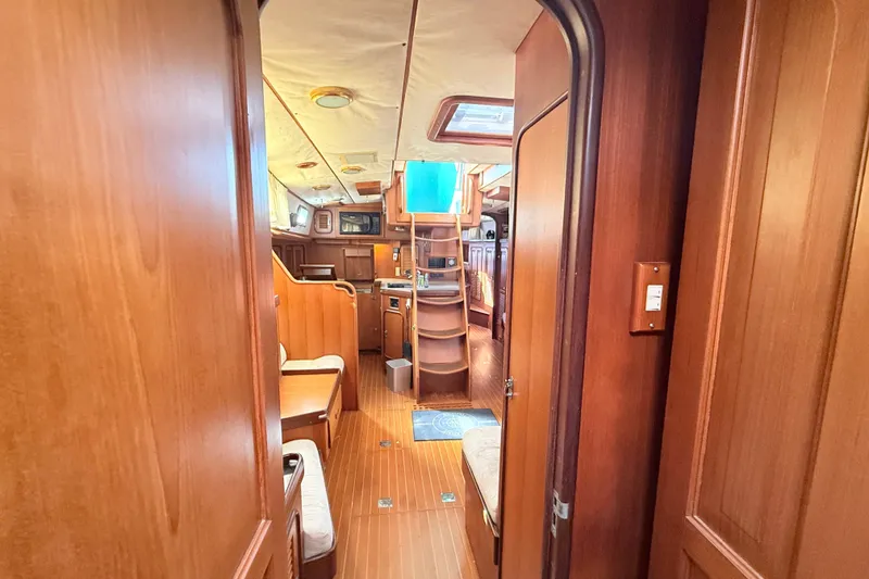 Slide: The Image of Interior of a 1999 Passport 456 yacht, featuring wooden finishes and cozy seating. - 30