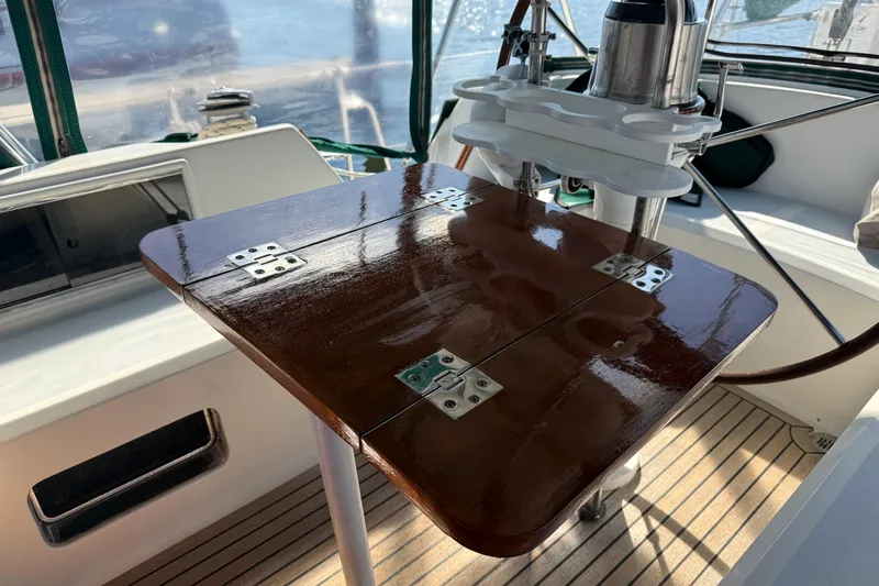 Slide: The Image of Polished wooden table on a 1999 Passport 456 yacht deck, with metal hinges and nautical equipment. - 33