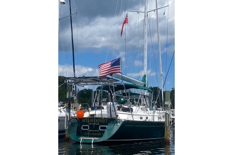 Slide: The Image of Sailboat "Wild Spirit" docked, displaying American flag, under cloudy sky. - 4