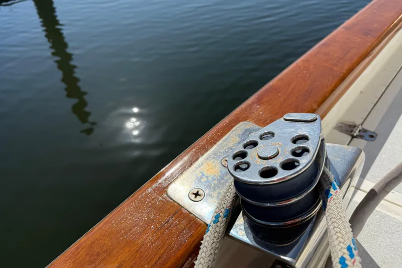 Slide: The Image of Sailboat deck with winch and rope, reflecting sunlight on water. Passport 456, 1999 model. - 48