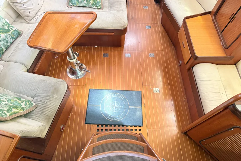 Slide: The Image of Interior of a 1999 Passport 456 yacht with wooden flooring and cushioned seating. - 5