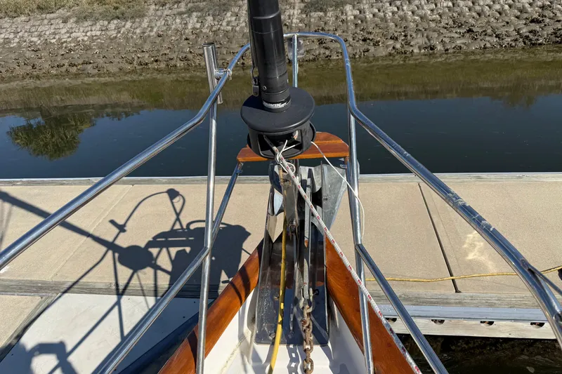 Slide: The Image of Bow of a 1999 Passport 456 sailboat docked by a calm riverbank. - 50