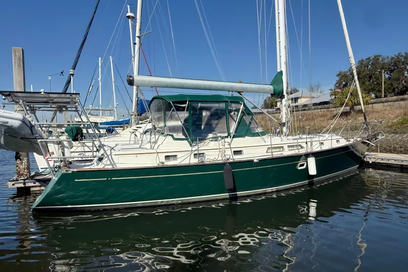Slide: The Image of Sailboat docked in marina, Passport 456 model, 1999, with green hull and canopy. - 56
