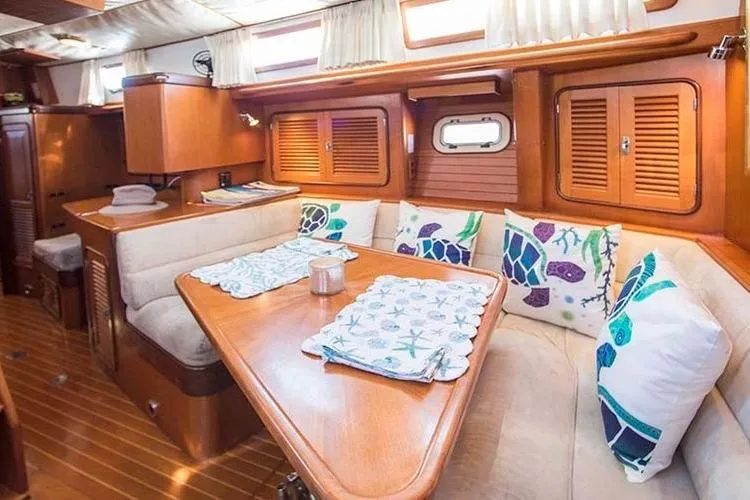 Slide: The Image of Cozy yacht interior with wooden finish, cushioned seating, and nautical-themed pillows. Passport 456, 1999. - 8