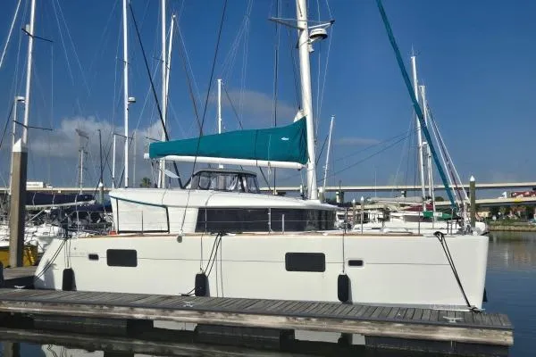The Image of 2011 Lagoon 400 catamaran docked at marina with blue sail cover. - 1