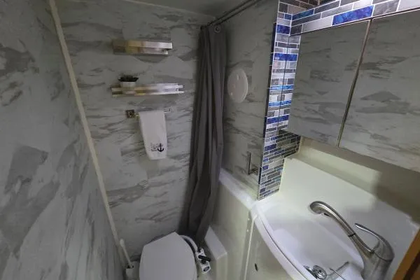 Slide: The Image of Compact bathroom in a 2011 Lagoon 400 yacht with modern fixtures and blue tile accents. - 12