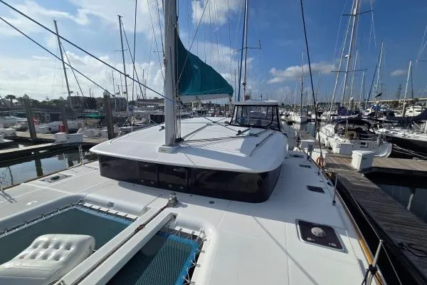 Slide: The Image of 2011 Lagoon 400 catamaran docked at marina under clear blue sky. - 15