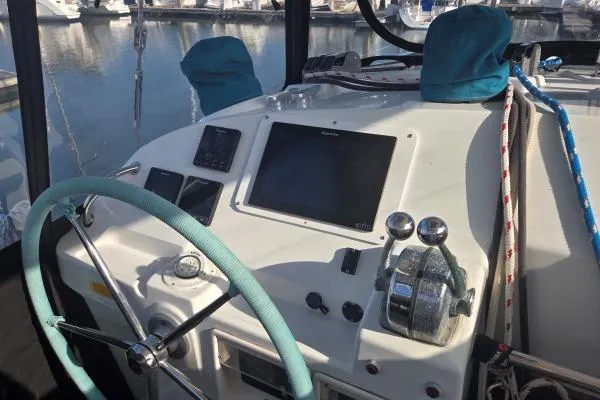 Slide: The Image of Helm of 2011 Lagoon 400 catamaran with steering wheel and navigation controls. - 16