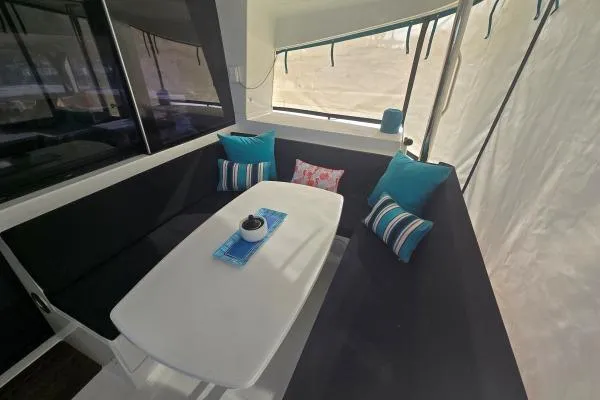 Slide: The Image of Cozy seating area on 2011 Lagoon 400 catamaran with colorful cushions and table. - 18