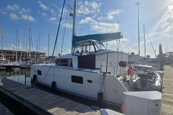 Slide: The Image of 2011 Lagoon 400 catamaran docked at marina under clear blue sky. - 25