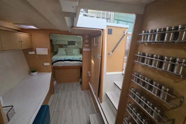Slide: The Image of Interior of 2011 Lagoon 400 catamaran with modern kitchen and cozy bedroom. - 5