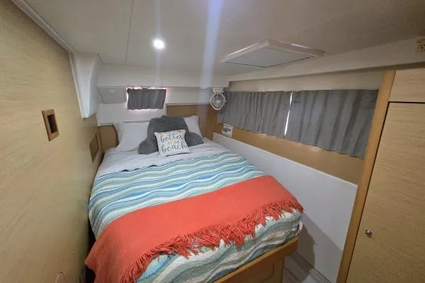 Slide: The Image of Cozy bedroom in 2011 Lagoon 400 catamaran with colorful bedding and nautical decor. - 8