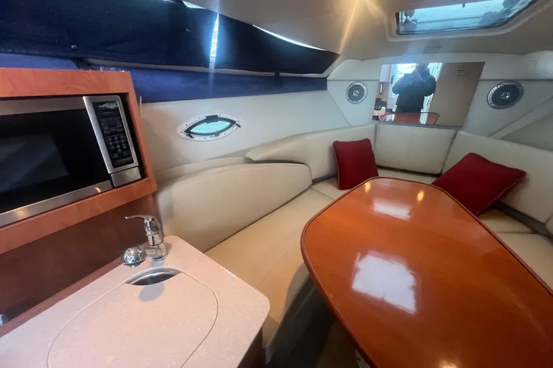 Slide: The Image of Interior of 2008 Bayliner 245 Cruiser with kitchenette and cozy seating area. - 10