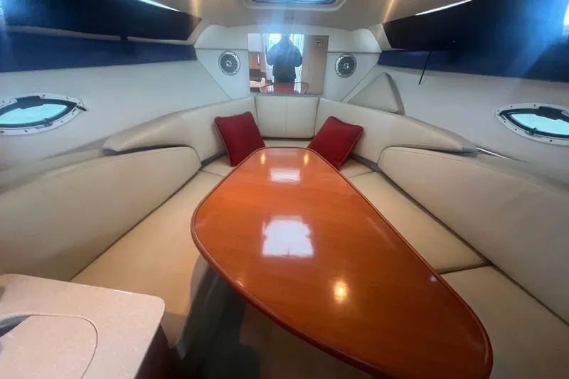 Slide: The Image of Interior of 2008 Bayliner 245 Cruiser with beige seating and wooden table. - 11