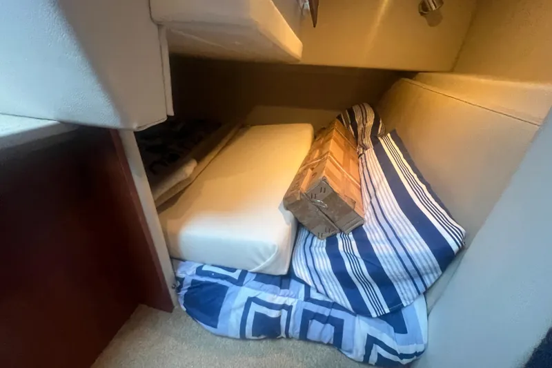 Slide: The Image of Interior cabin of 2008 Bayliner 245 Cruiser with striped bedding and cushions. - 12