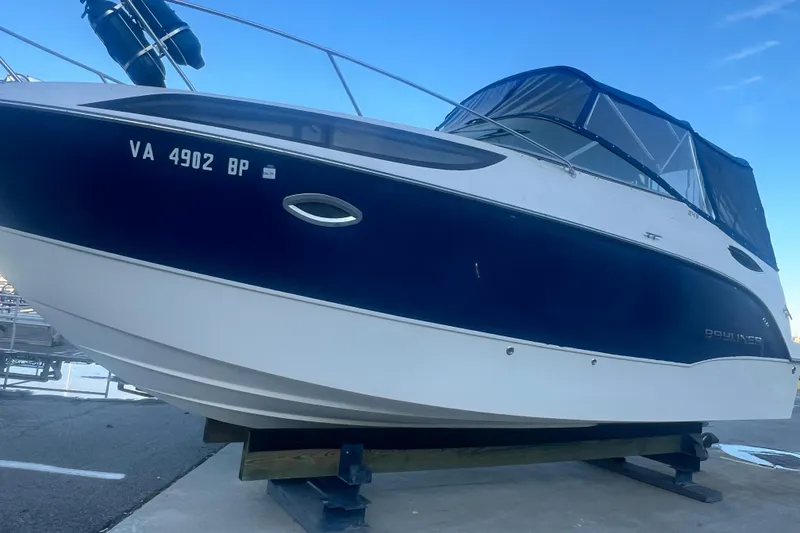 Slide: The Image of 2008 Bayliner 245 Cruiser boat on a stand, featuring a sleek design and blue canopy. - 27