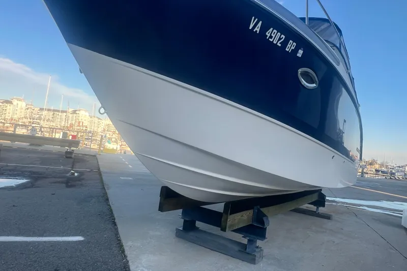 Slide: The Image of 2008 Bayliner 245 Cruiser on dry dock at marina, blue and white hull. - 28