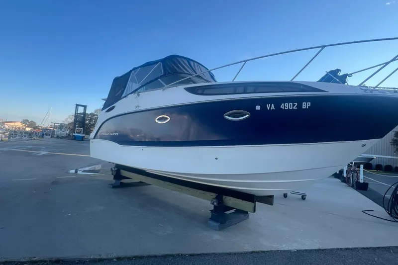 Slide: The Image of 2008 Bayliner 245 Cruiser boat on dry dock, blue and white exterior. - 30