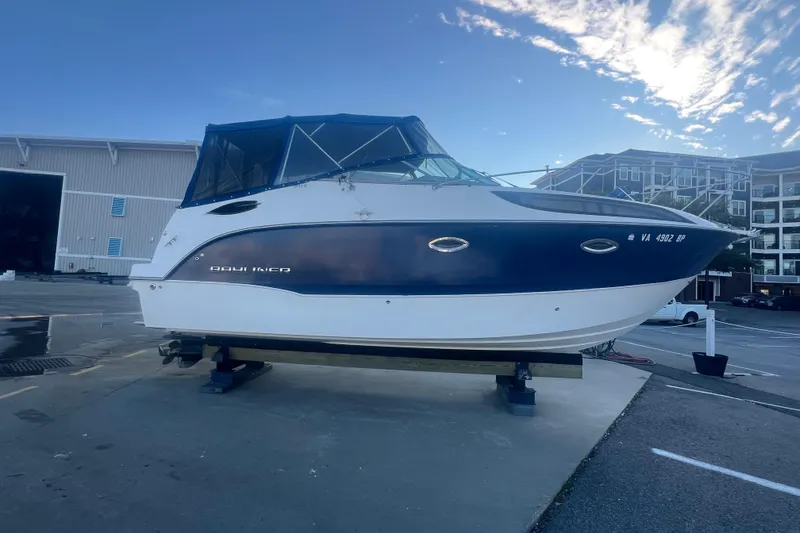 Slide: The Image of 2008 Bayliner 245 Cruiser boat on dry dock, blue and white exterior, marina background. - 31