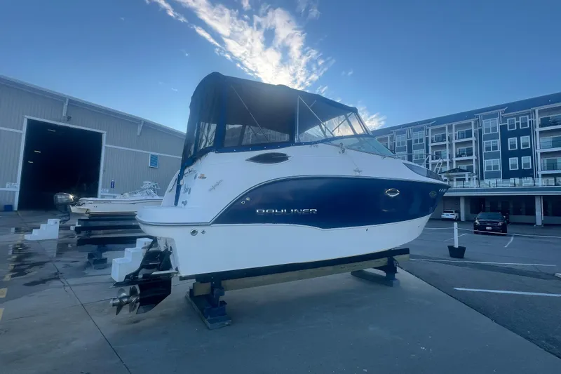 Slide: The Image of 2008 Bayliner 245 Cruiser on dry dock, blue and white exterior, marina background. - 32