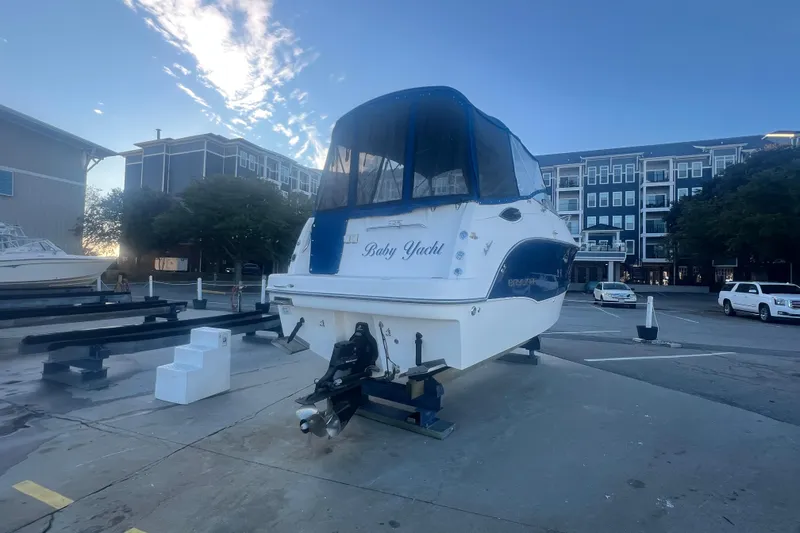 Slide: The Image of 2008 Bayliner 245 Cruiser on trailer, dockside with buildings in background. - 33