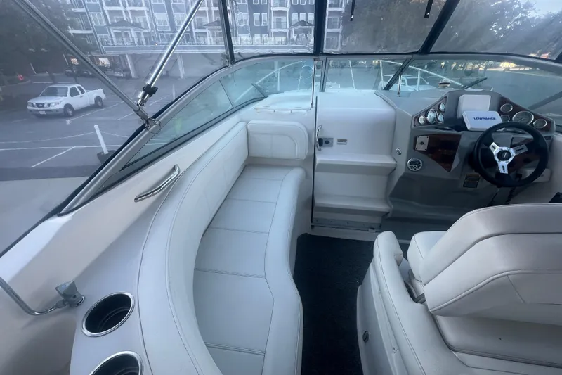 Slide: The Image of 2008 Bayliner 245 Cruiser interior with white seating and steering console. - 4