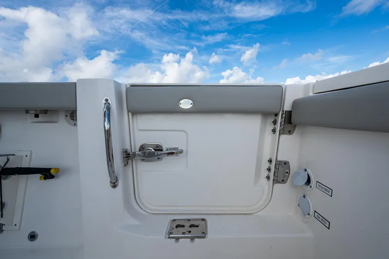 Slide: The Image of 2023 Pursuit S 358 Sport boat interior with sky view, featuring a door and handle. - 19