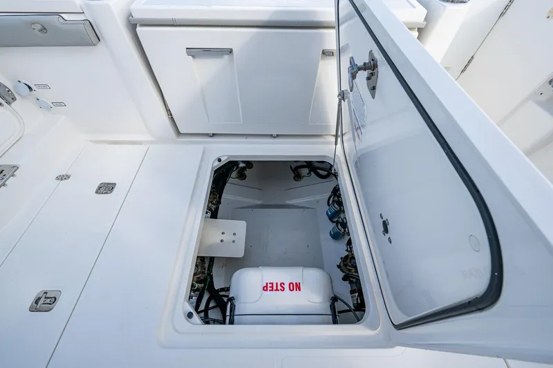 Slide: The Image of 2023 Pursuit S 358 Sport boat storage compartment with open hatch. - 21