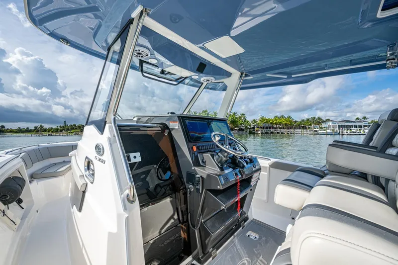 Slide: The Image of 2023 Pursuit S 358 Sport boat interior with helm, seats, and waterfront view. - 34