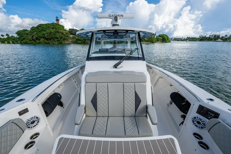 Slide: The Image of 2023 Pursuit S 358 Sport boat interior with luxurious seating on a scenic waterway. - 35