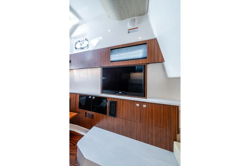 Slide: The Image of 2023 Pursuit S 358 Sport interior with wood paneling and mounted TV. - 46