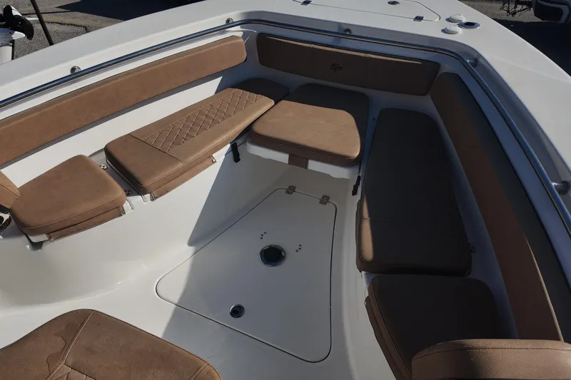 Slide: The Image of 2023 Sea Pro boat interior with tan cushioned seating and storage compartments. - 12