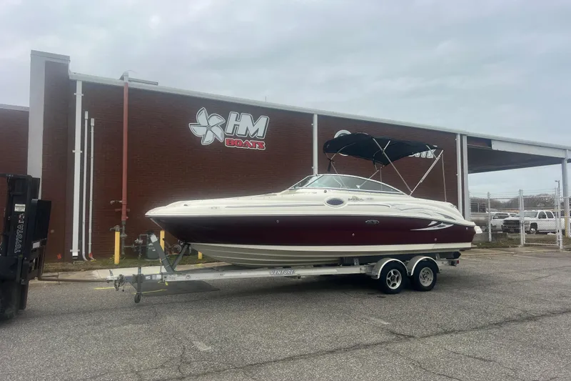 The Image of 2006 Sea Ray 240 Sundeck boat on trailer, featuring a red and white design. - 0