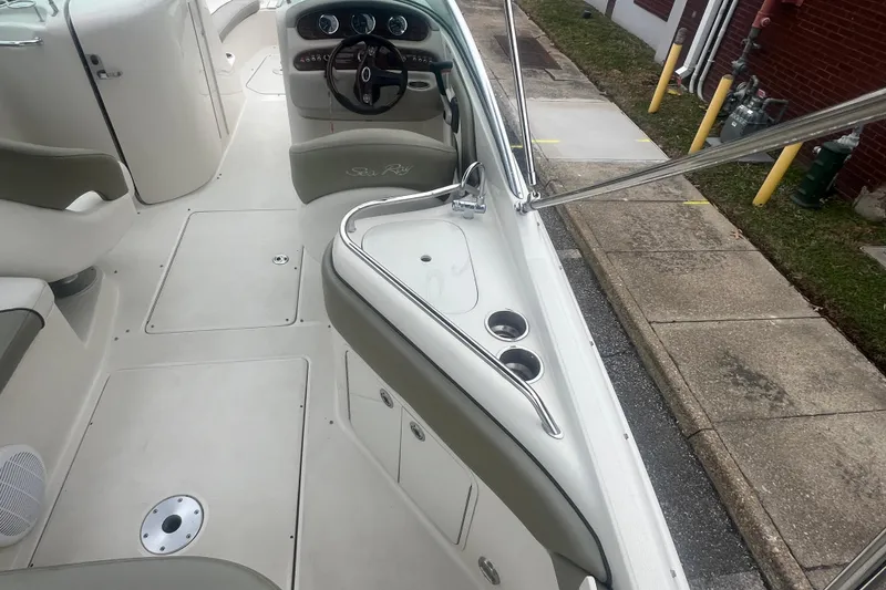 Slide: The Image of 2006 Sea Ray 240 Sundeck interior with white and gray seating. - 12