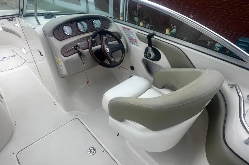 Slide: The Image of 2006 Sea Ray 240 Sundeck interior with steering wheel and seating area. - 13