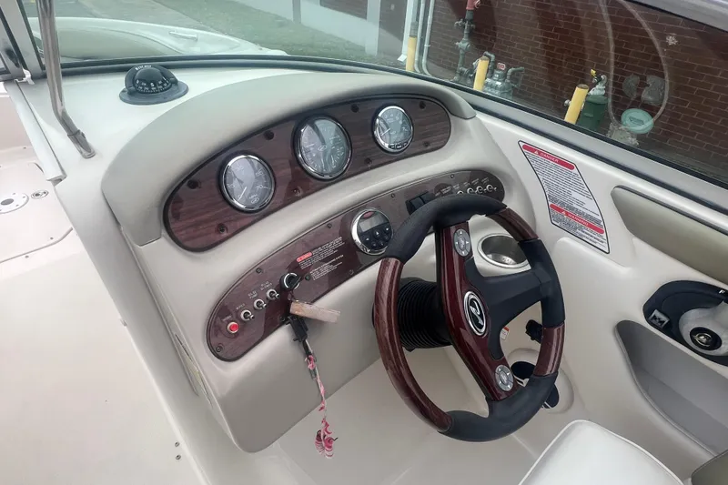 Slide: The Image of 2006 Sea Ray 240 Sundeck boat interior with steering wheel and dashboard controls. - 14