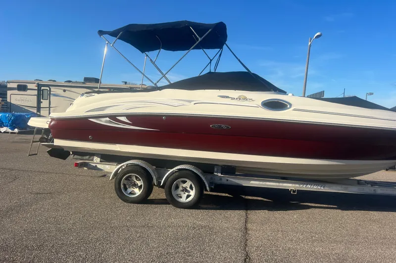 Slide: The Image of 2006 Sea Ray 240 Sundeck boat on trailer with canopy, parked outdoors. - 34