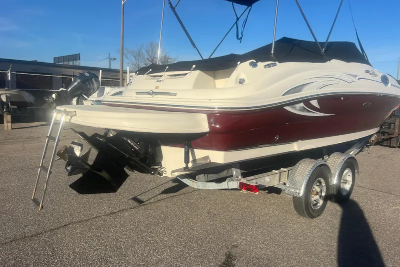 Slide: The Image of 2006 Sea Ray 240 Sundeck boat on trailer, featuring maroon and white design. - 37