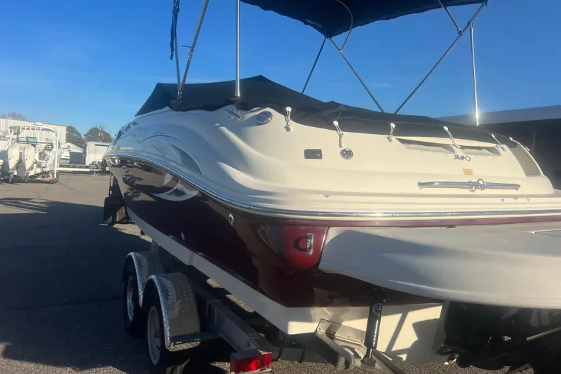 Slide: The Image of 2006 Sea Ray 240 Sundeck boat on trailer, featuring a sleek design and canopy. - 39