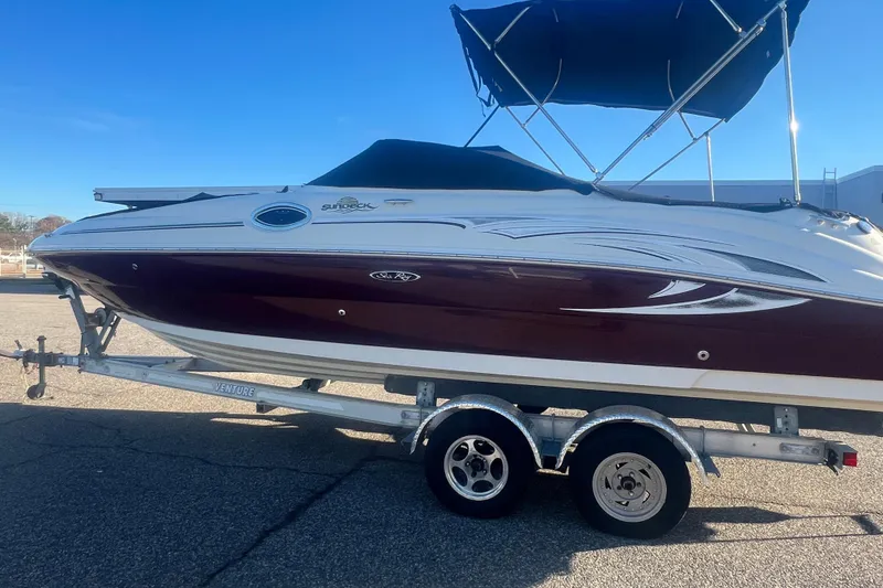 Slide: The Image of 2006 Sea Ray 240 Sundeck boat on trailer with canopy, parked outdoors. - 41
