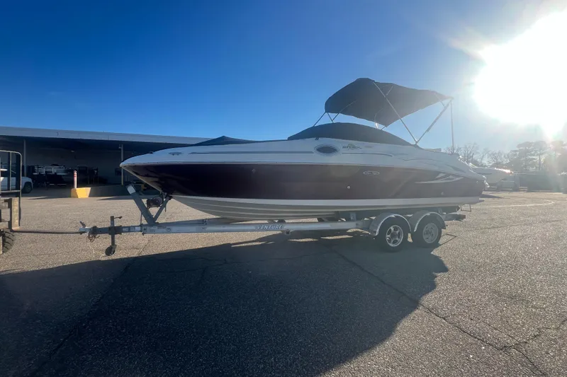 Slide: The Image of 2006 Sea Ray 240 Sundeck boat on trailer under bright sunlight. - 42