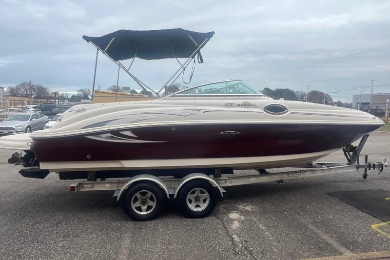 Slide: The Image of 2006 Sea Ray 240 Sundeck boat on trailer, parked outdoors. - 6