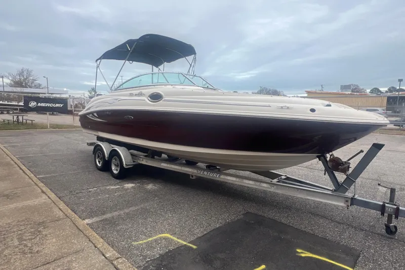 Slide: The Image of 2006 Sea Ray 240 Sundeck boat on trailer with canopy, parked outdoors. - 7