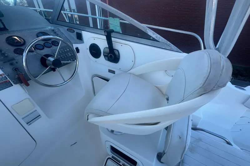 Slide: The Image of 2004 Trophy 2352 Walkaround boat cockpit with steering wheel and captain's chair. - 13