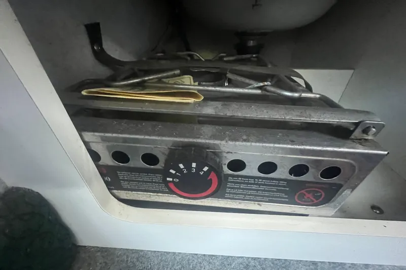 Slide: The Image of 2004 Trophy 2352 Walkaround boat stove with control dial and storage compartment. - 26