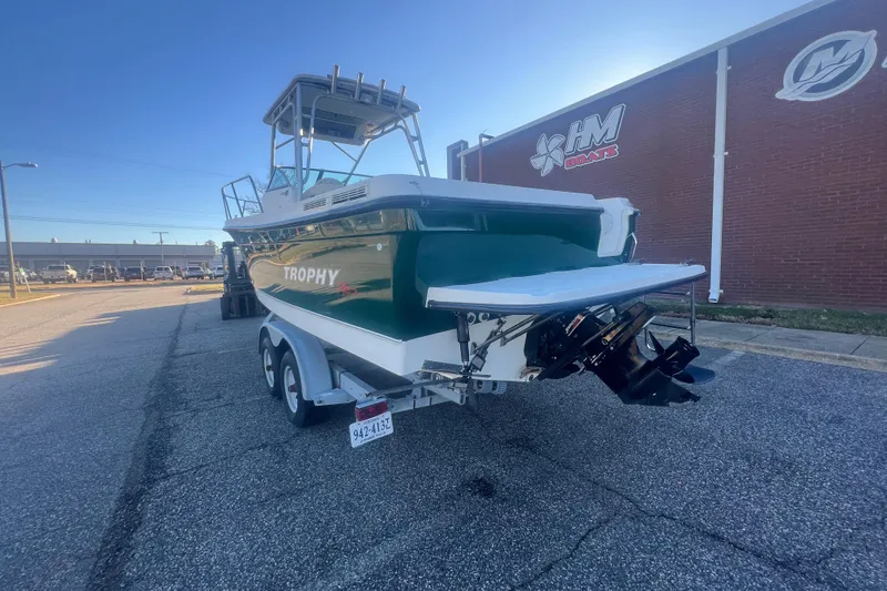 Slide: The Image of 2004 Trophy 2352 Walkaround boat on trailer, parked near a brick building. - 3