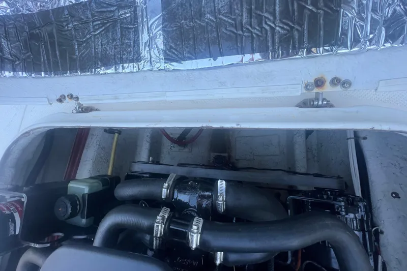 Slide: The Image of Engine compartment of a 2004 Trophy 2352 Walkaround boat, showing hoses and components. - 33