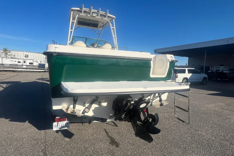Slide: The Image of 2004 Trophy 2352 Walkaround boat, green hull, parked outdoors, rear view with outboard motor. - 38